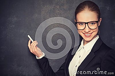 Business woman teacher with glasses and a suit with chalk at a Stock Photo