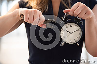 Business woman try to adjust time on alarm clock after shocked with late in rush hours when going to work in city urban background Stock Photo