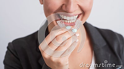 Business woman uses transparent braces to whiten teeth Stock Photo