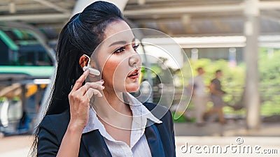 Business woman using earphone outdoor in city Stock Photo