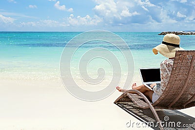 Business woman using laptop computer on the beach Stock Photo