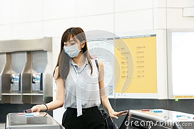 Business Woman wear medical mask and hand scanning train ticket to subway entrance gate Stock Photo