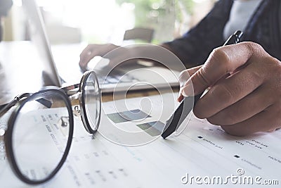 Business woman working at the office. analysis document and using laptop. vintage filter. Stock Photo