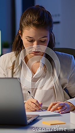 Business woman working overtime to respect deadline of project sitting in business office Stock Photo