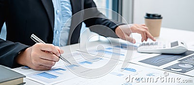 Business woman are working by reviewing the numeric data from the graph using a calculator Stock Photo