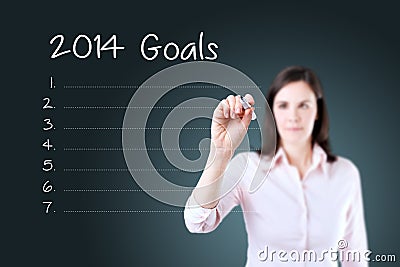 Business woman writing blank 2014 goals list. Blue background. Stock Photo