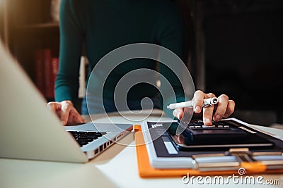 Women calculates financials with graph paper on the table on the cost of home office. Stock Photo