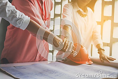 Business women and engineer working hands of business people joined hands together in office meeting. Teamwork Concept and Stock Photo