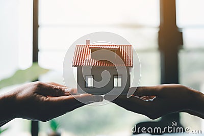 Business woman holding home miniature in office bureau. insurance protective hand over house for protection and care, Concept of Stock Photo
