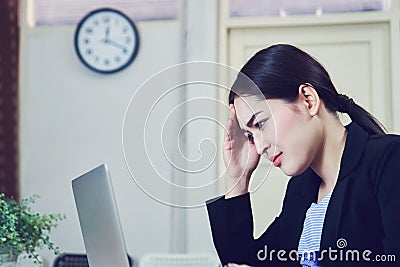 Business women sit and strain the computer screen for a long time. Because the work has been overloaded. Stock Photo