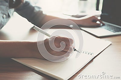 Business women using computer and calculator during note some data on notepad for calculate financial Stock Photo