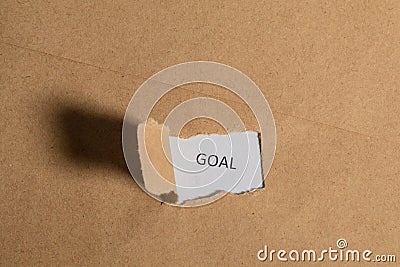 The business word Goal written on vintage paper. Top view. Torn paper revealing the word. Innovation and ideas Stock Photo