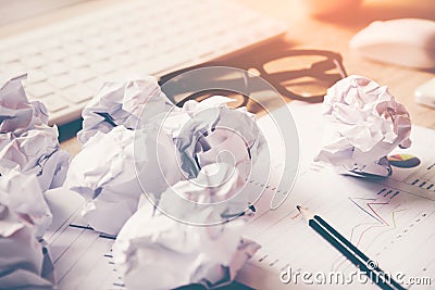 Business workplace with keyboard mouse and crumpled paper balls ,papers with graphs and diagrams . Stock Photo