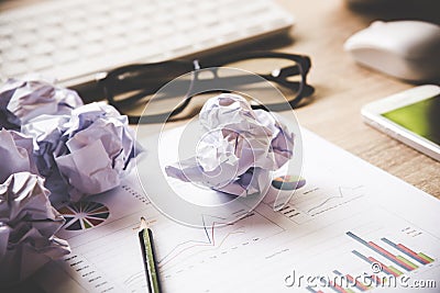 Business workplace with keyboard mouse and crumpled paper balls ,papers with graphs and diagrams . Stock Photo