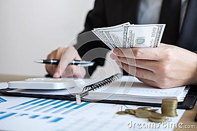 Businessman accountant counting money and making notes at report doing finances and calculate about cost of investment and Stock Photo