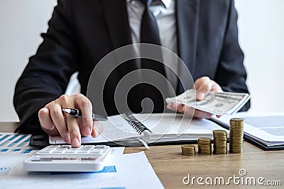 Businessman accountant counting money and making notes at report doing finances and calculate about cost of investment and Stock Photo