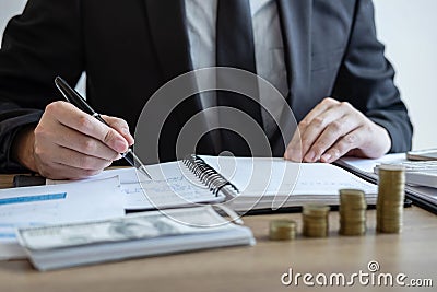 Businessman accountant counting money and making notes at report doing finances and calculate about cost of investment and Stock Photo