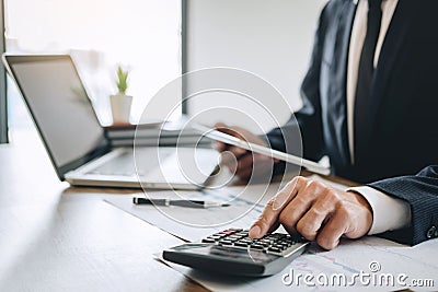 Businessman accountant working new project on laptop computer with report document and analyze document graph and diagram, doing Stock Photo