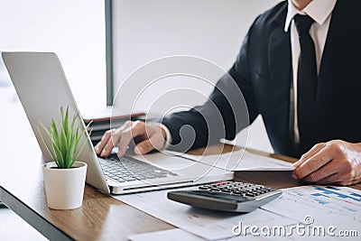 Businessman accountant working new project on laptop computer with report document and analyze document graph and diagram, doing Stock Photo