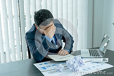 Businessman acted with tired stress anxiety from the frustrated business crisis, paperwork paper cube mess chaos on the table Stock Photo