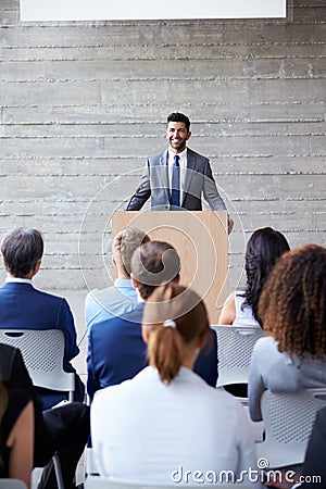 Businessman Addressing Delegates At Conference Stock Photo