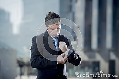 Businessman adjusting shirt cuff link outdoors exterior office building Stock Photo