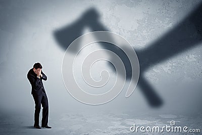 Businessman afraid of a huge shadow hand holding an axe concept Stock Photo