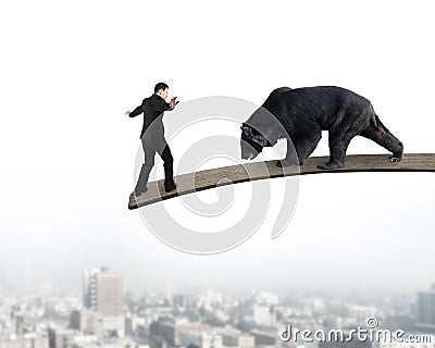 Businessman against black bear balancing on wooden board with ci Stock Photo