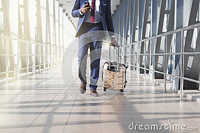 Businessman at airport moving to terminal gate for business trip, front view Stock Photo