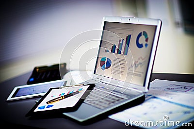 Businessman analyzing investment charts with laptop Stock Photo