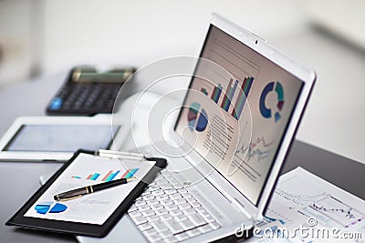 Businessman analyzing investment charts with laptop Stock Photo