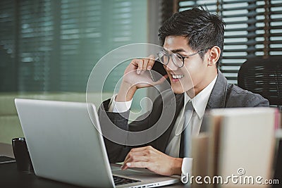 Businessman analyzing investment charts with Smartphones and laptop Stock Photo