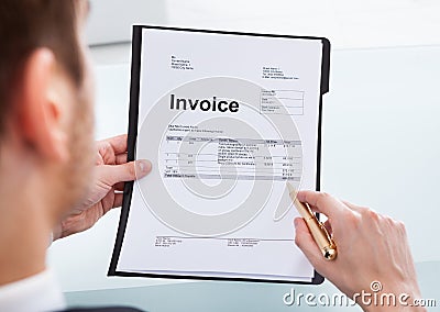 Businessman analyzing invoice at office desk Stock Photo