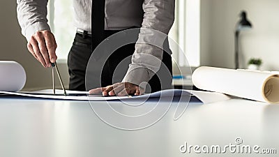 Businessman or arhitect in grey shirt using ruler and pair of co Stock Photo
