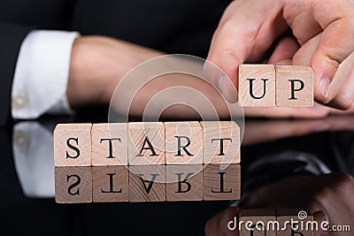 Businessman arranging startup blocks on desk Stock Photo