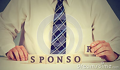 Businessman arranging wooden blocks on table. Business sponsor scholarship concept Stock Photo