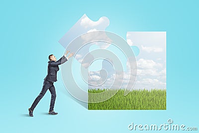 Businessman assembling puzzle piece with picture of nature on blue background Stock Photo