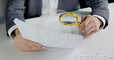Businessman or auditor inspecting document with magnifying glass in office. business financial audit or contract reading concept Stock Photo
