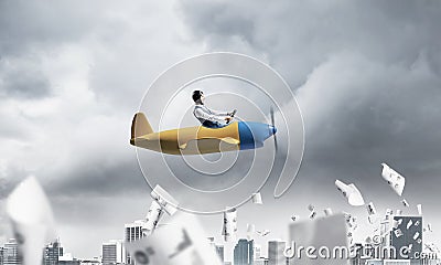 Businessman in aviator hat driving paper plane Stock Photo