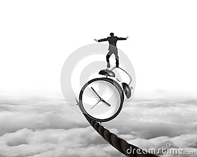 Businessman balancing alarm clock on tightrope Stock Photo
