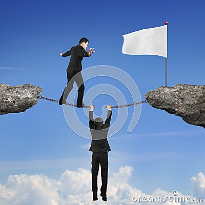 Businessman balancing on broken chain another man holding toward Stock Photo