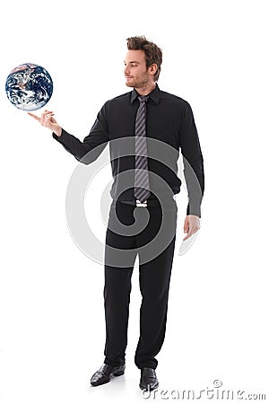 Businessman balancing globe on forefinger Stock Photo