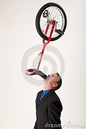 Businessman balancing unicycle Stock Photo