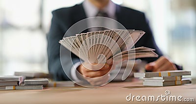Businessman banker holding fan of dollar bills in hand closeup Stock Photo