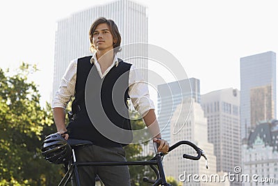 Businessman With Bicycle Standing In City Park Stock Photo