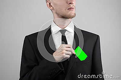 Businessman in a black suit and black tie holding a card, a hand holding a card, green card, card is inserted, the green chroma Stock Photo