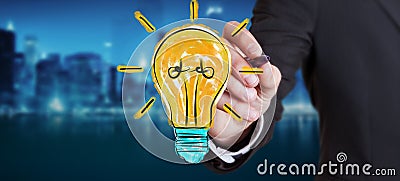 Businessman drawing a lightbulb sketch Stock Photo