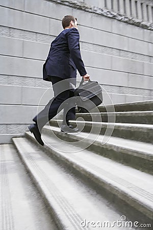 Businessman With Briefcase Ascending Steps Stock Photo