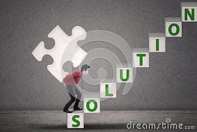 Businessman bring puzzle solution on grey Stock Photo