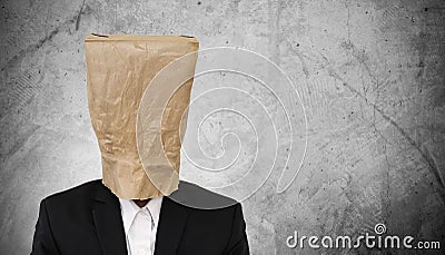 Businessman with brown paper bag on head, on dark concrete texture background, with copy space Stock Photo